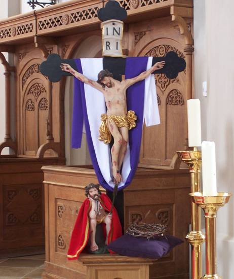 Kreuz und Herrgottsruhbild vor dem Chorgesthl in St. Peter Hofkirchen